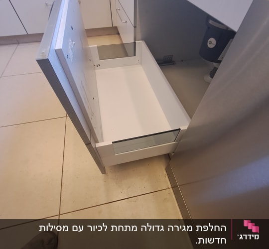 מגירת מטבח פתוחה ליד ארון נירוסטה